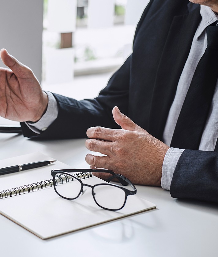businessperson with notebook and glasses in front of him